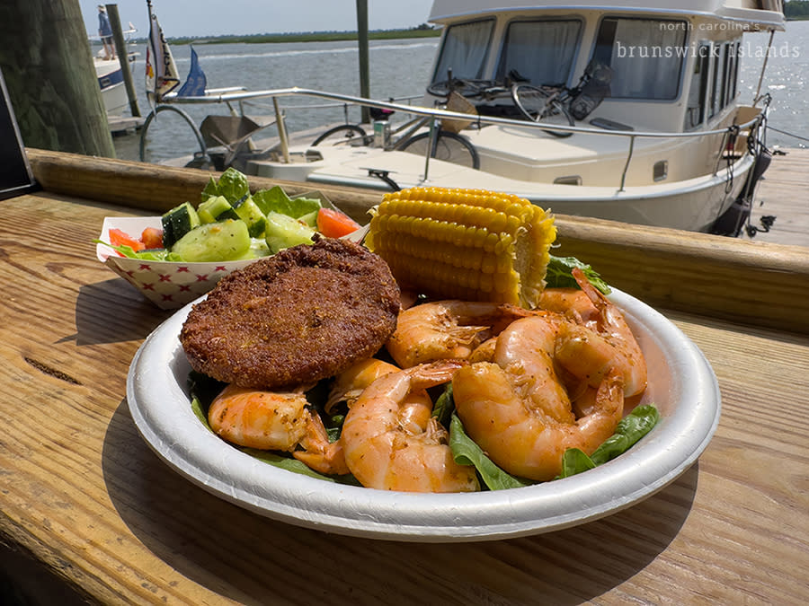 a plate of shrimp, a crab cake, and corn on the cob at Provision Company in Southport