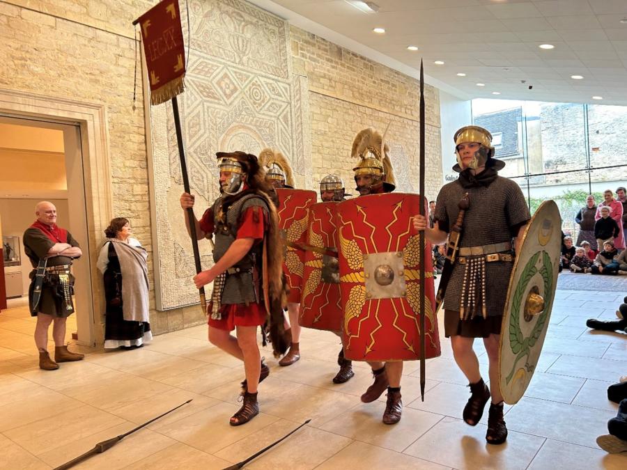 A group of soldiers walk through the Corinium Museum as part of a Roman Soldier re-enactment