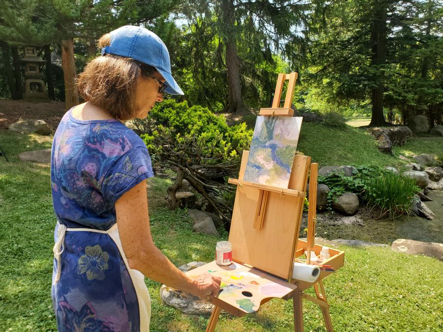 Woman doing plein air painting at Sonnenberg Gardens.
