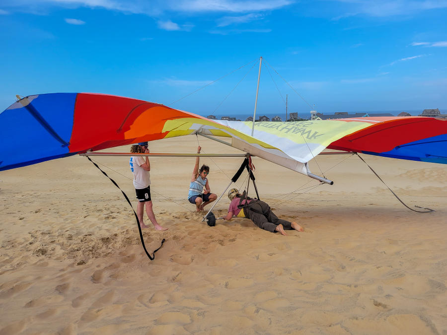 People checking a hang glider before flight