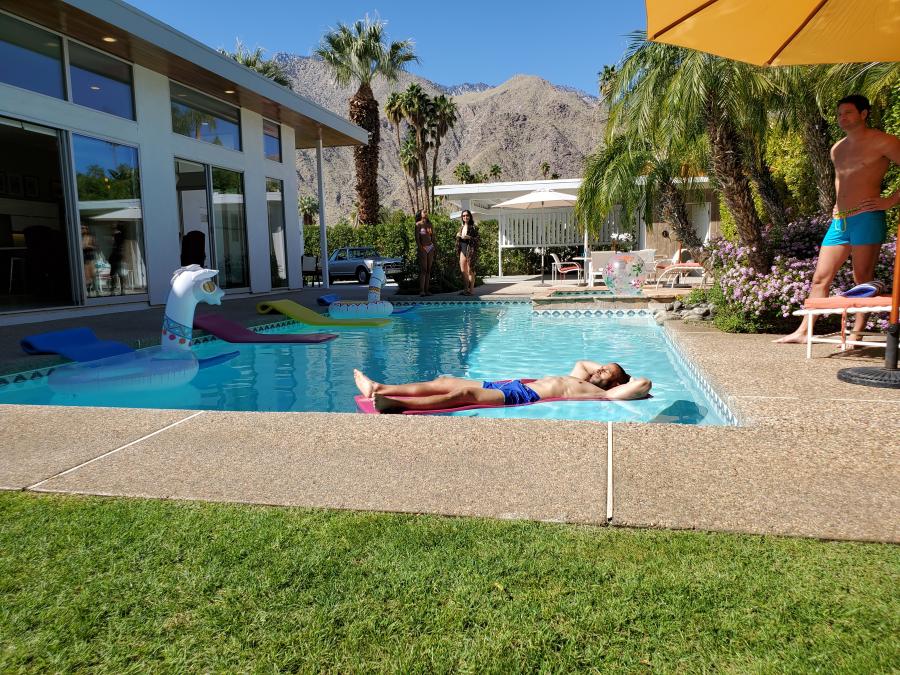 Two men at pool. ModMansions vacation rental.