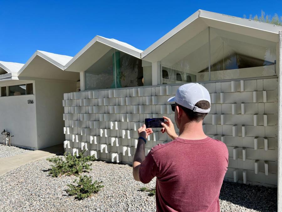 Man taking a photo in front of a midcentury houst, Modern Tours Palm Springs
