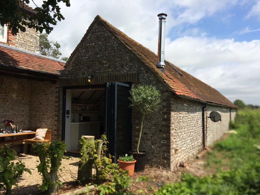 a flint building with bi fold doors in countryside