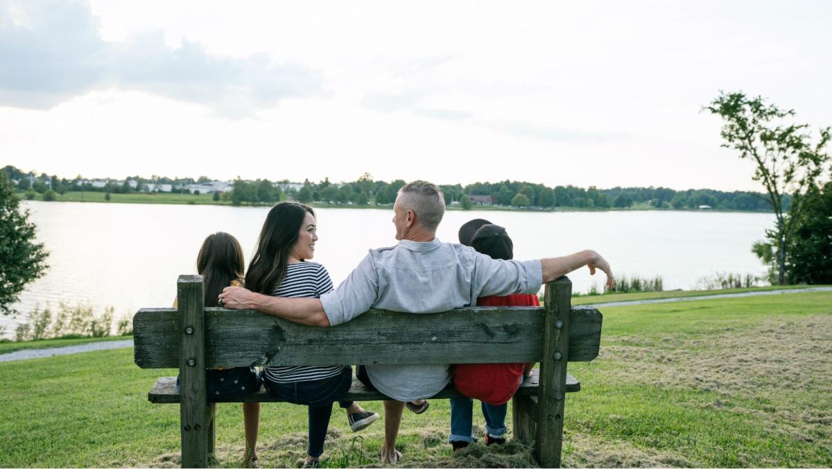 family sitting on a bench in front of freeman lake