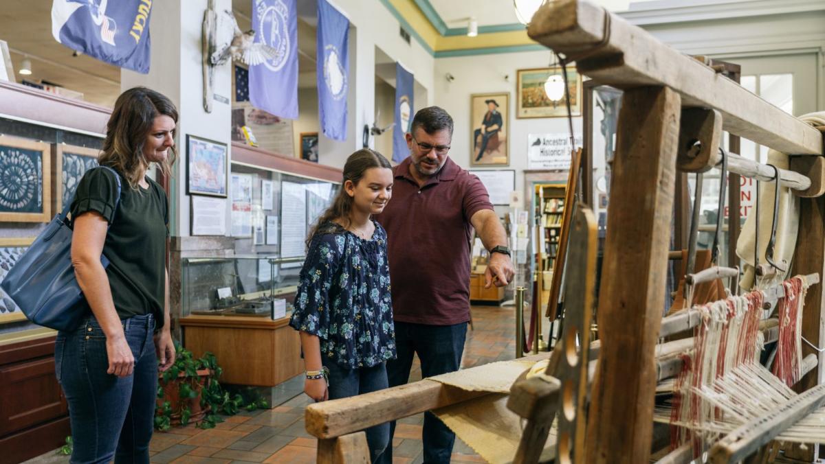 family observing artifact at the hardin county history museum