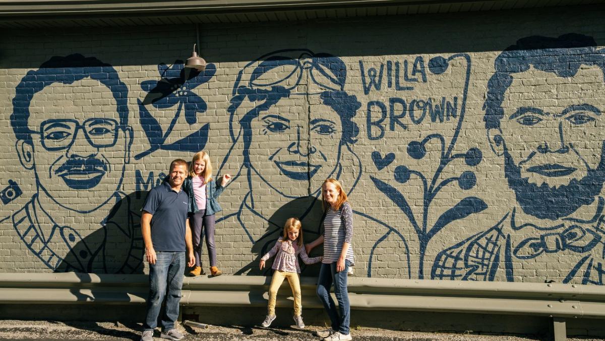 family in front of the kentucky natives mural