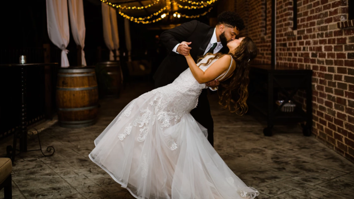 Couple kissing under the lights at a wedding