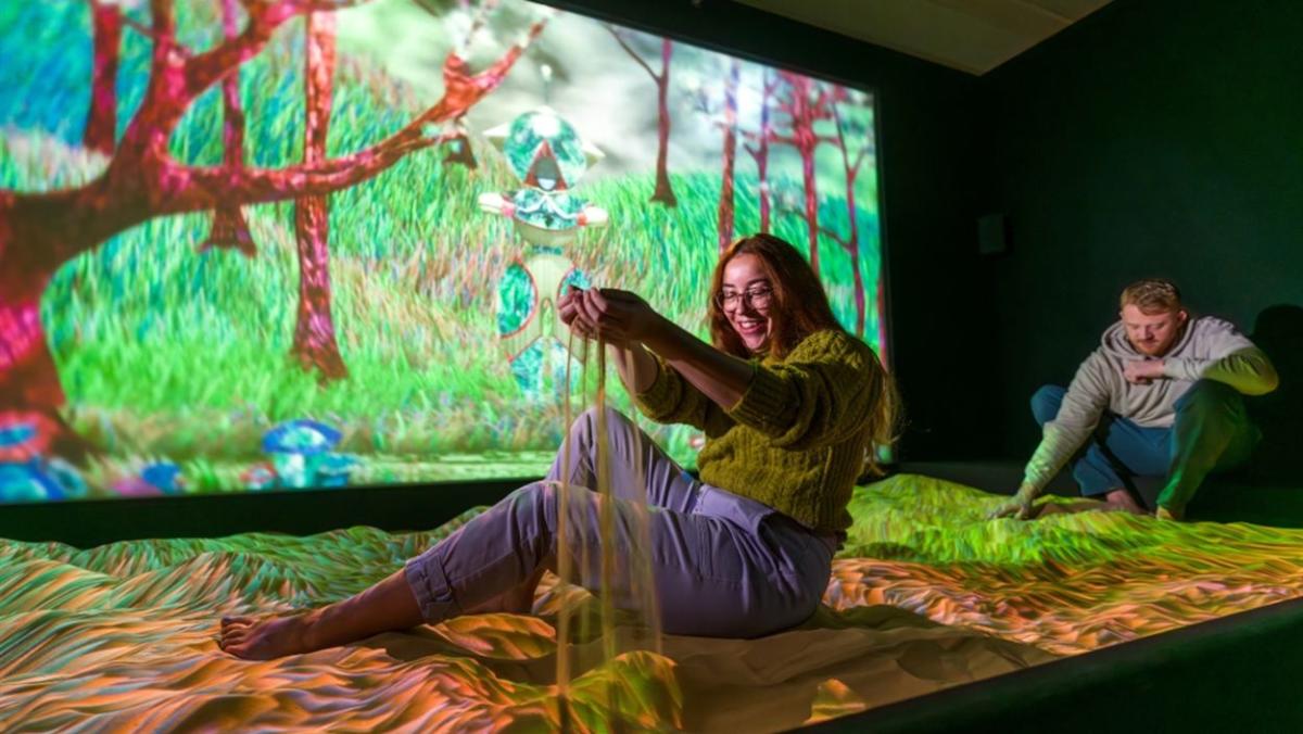 A girl plays with sand at the Subterranean Elevator