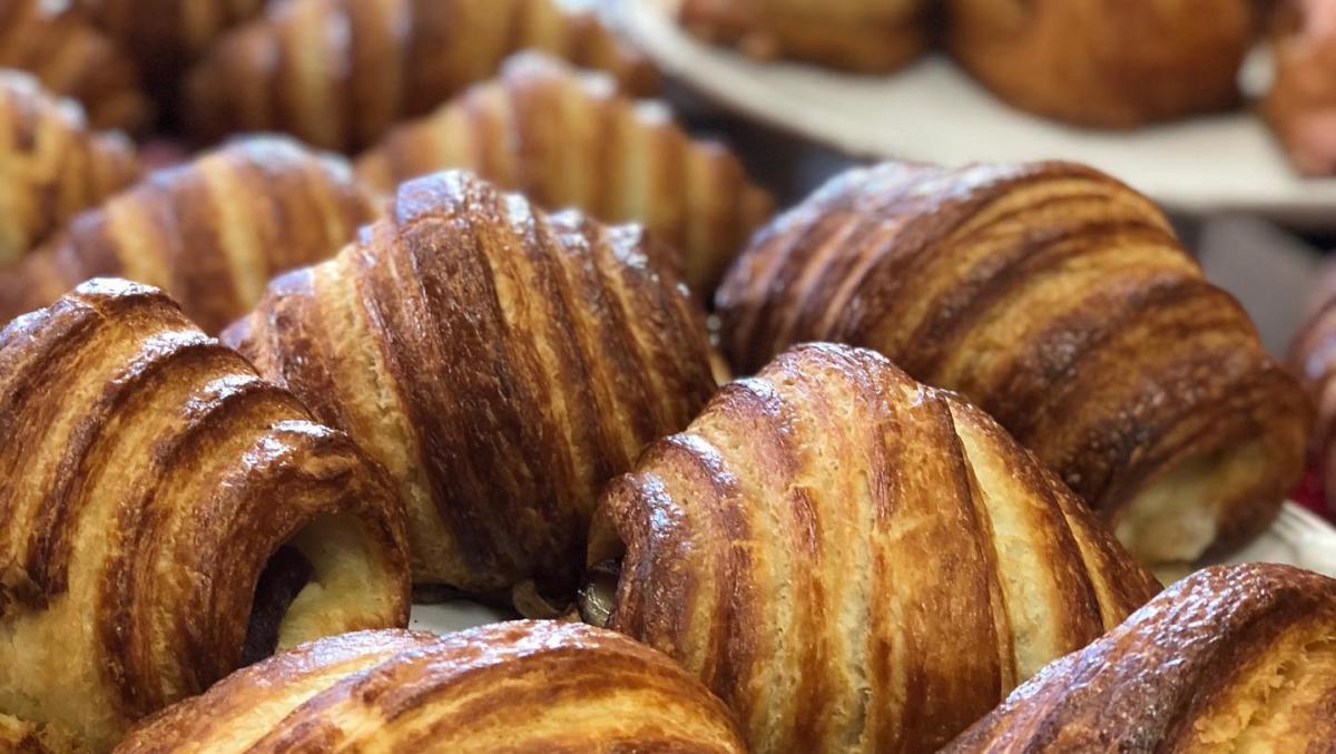 Image is of a bunch of golden brown, stuffed crossants.