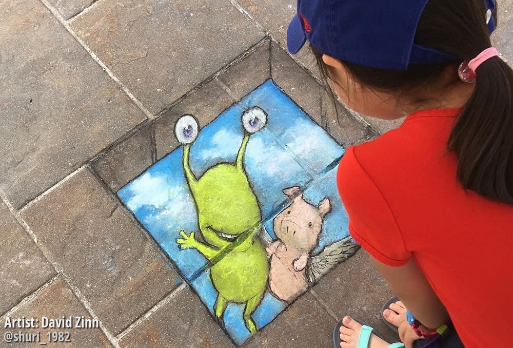 Child admires artwork by David Zinn at Ann Arbor Summerfest