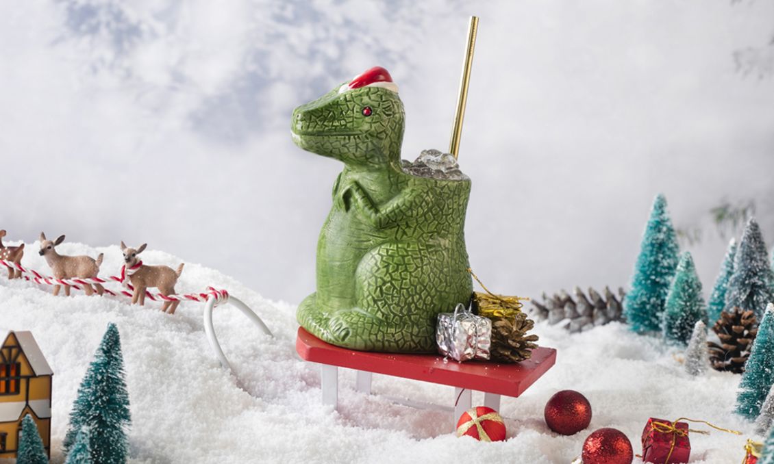 SanTaRex cocktail at The Haymaker - a display of the cocktail in its T-Rex mug towering over a small Christmas village display