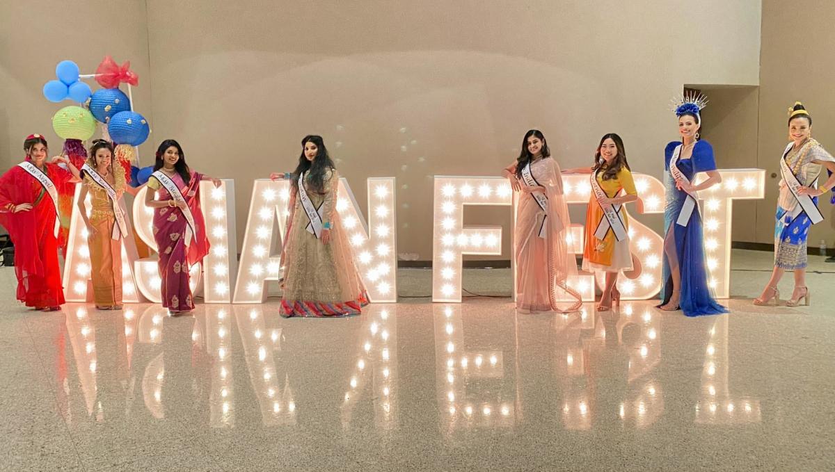 Pageant contestants pose in front of a lit "Asian Fest" sign during Wichita's Asian Fest