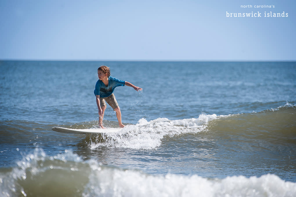 child standing on a surfboard
