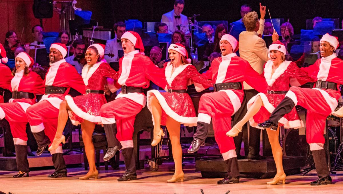 Santas dance in a kickline during Omaha Symphony's Christmas Celebration performance.