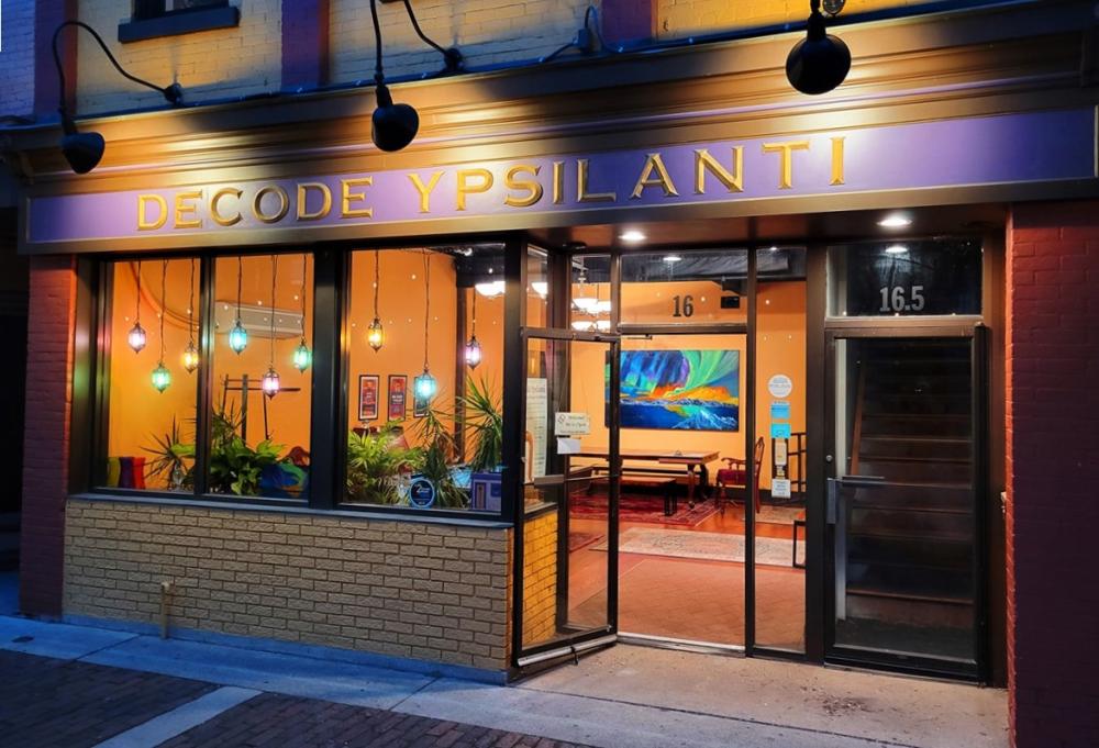 exterior view of building with windows and bricks spanning the entire storefront with words "Decode Ypsilanti" spelled across the top.