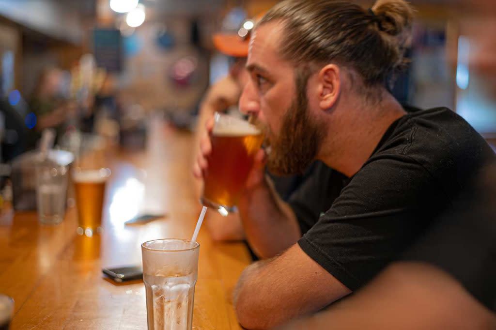 Man sitting at bar holding a drink