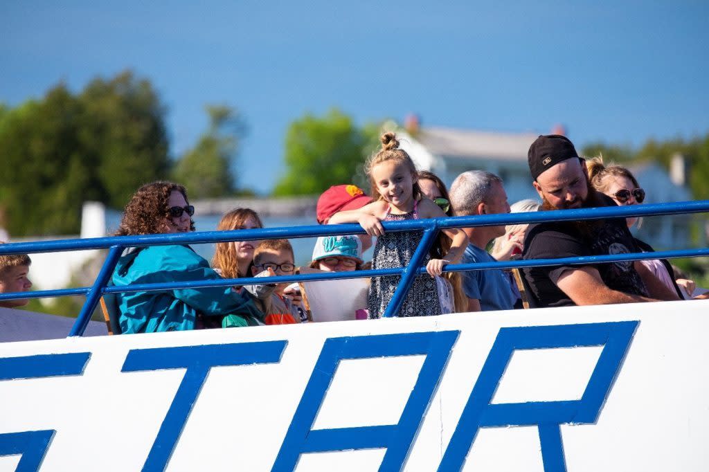 A girl smiles at the camera from the top deck of a Mackinac Island Ferry Company boat at Michigan’s Mackinac Island
