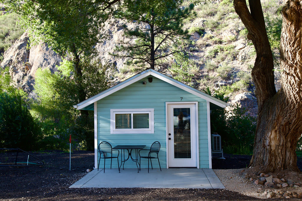 a blue cabin in the middle of a forest