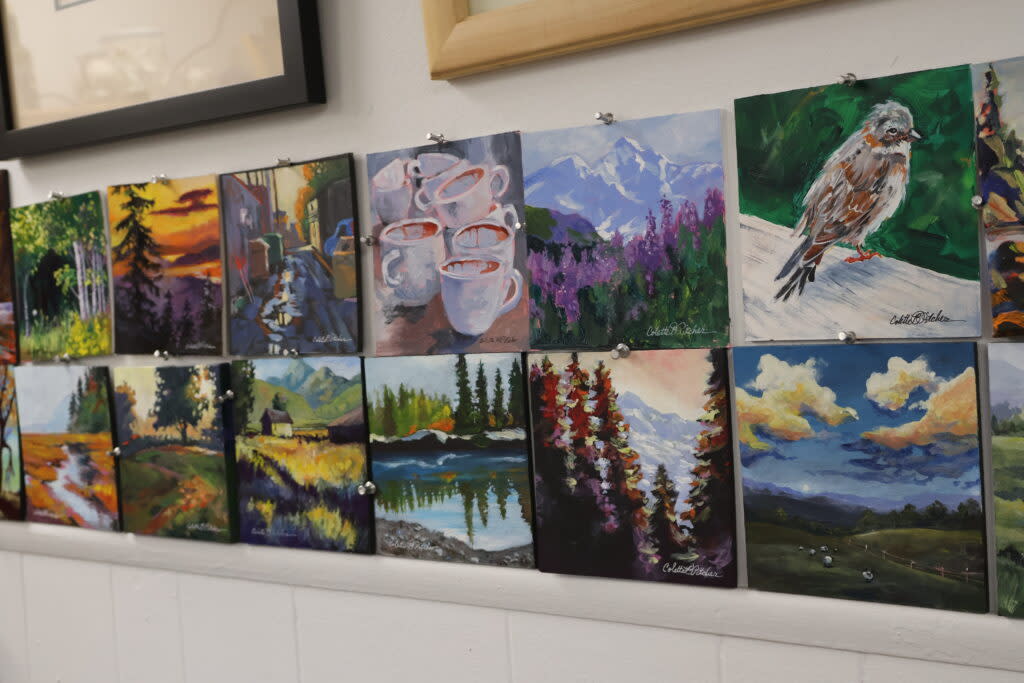 A gallery wall covered in colorful acrylic paintings in Greeley, Colorado