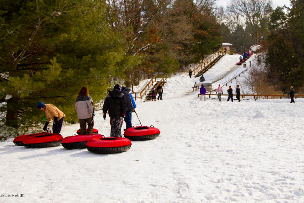 Snow tubers dragging their tubes to the top of the hill