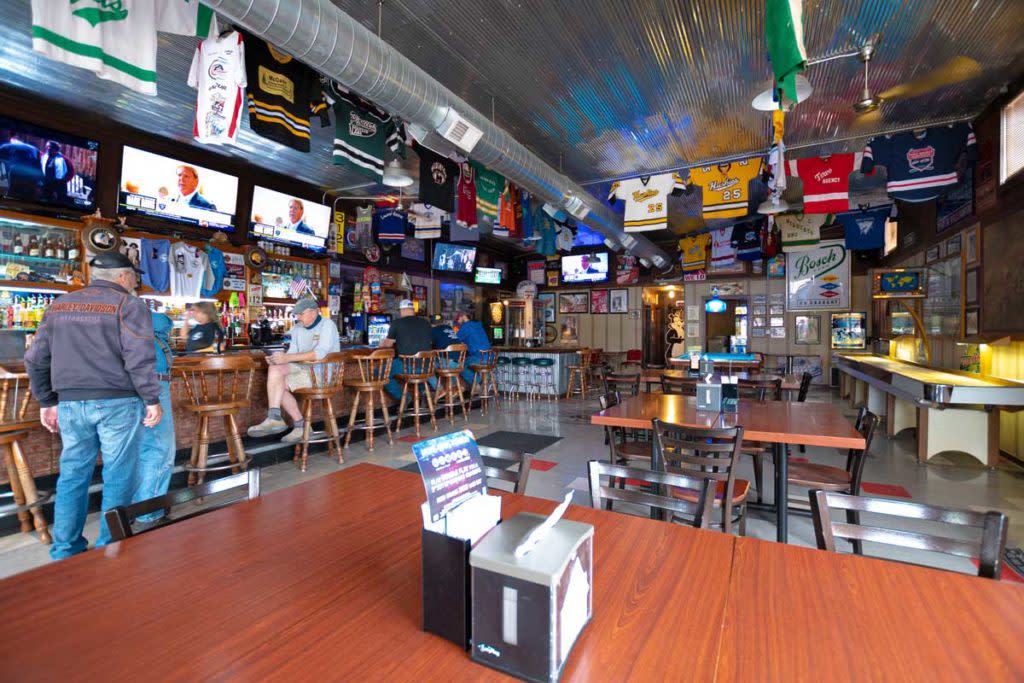 The interior of a bar with sports memorabilia hanging up
