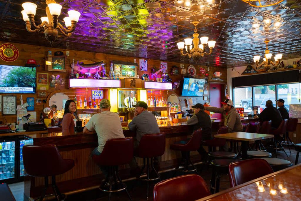 An old pub with people sitting at the bar