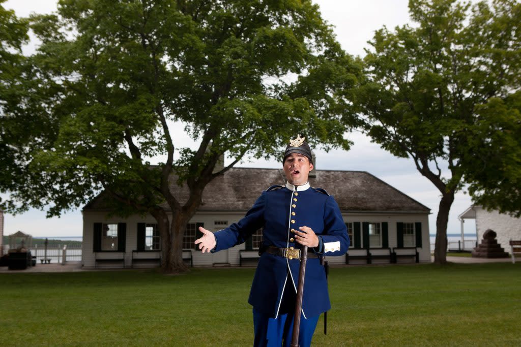 A historical interpreter speaks on the grounds of Mackinac Island's historic Fort Mackinac