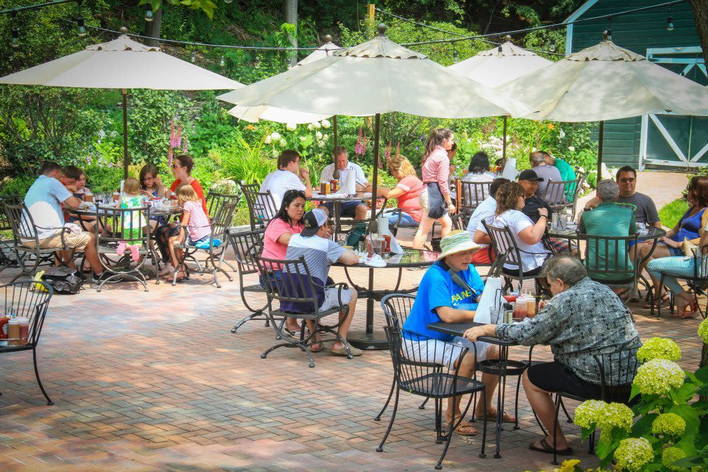 Groups of people dine on the outdoor patio at Ice House BBQ at Mackinac Island’s Island House Hotel