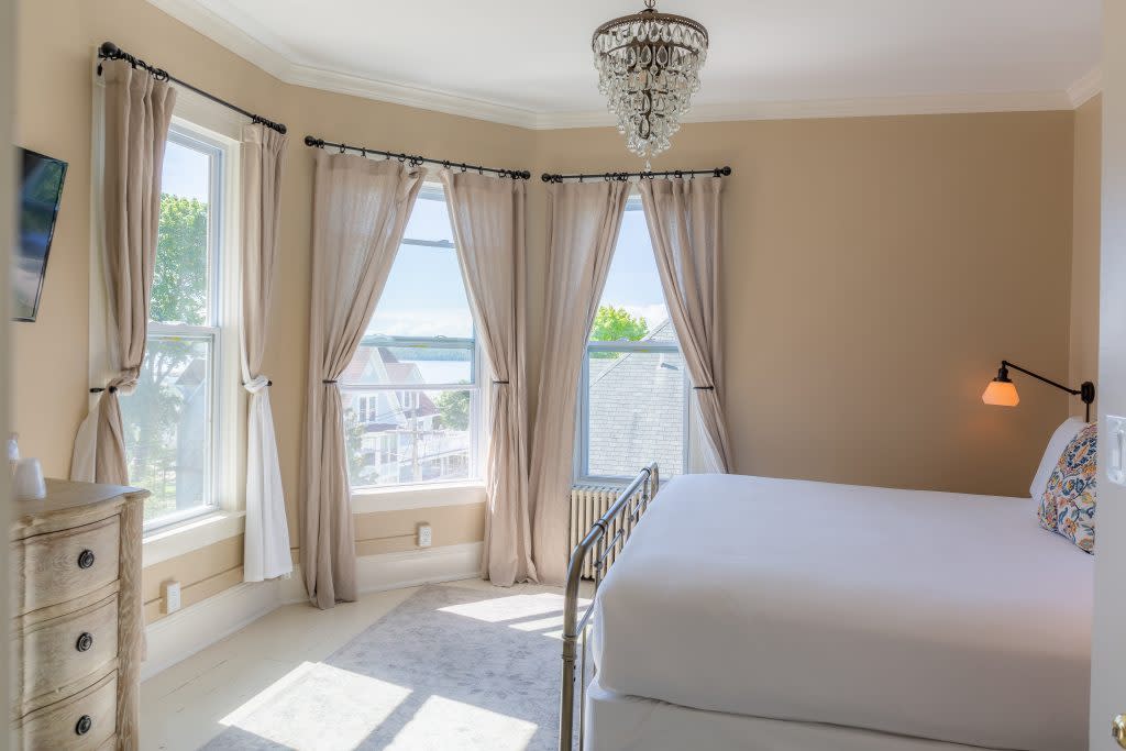 Windows in a bedroom at Pine Cottage B&B on Mackinac Island overlook other historic structures on Bogan Lane. 