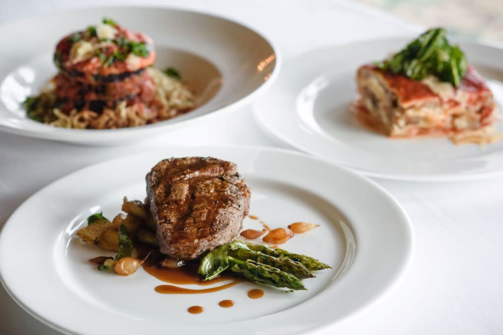 Three exquisite plates of food on a table at Chianti, a fine dining restaurant at Mackinac Island’s Mission Point Resort