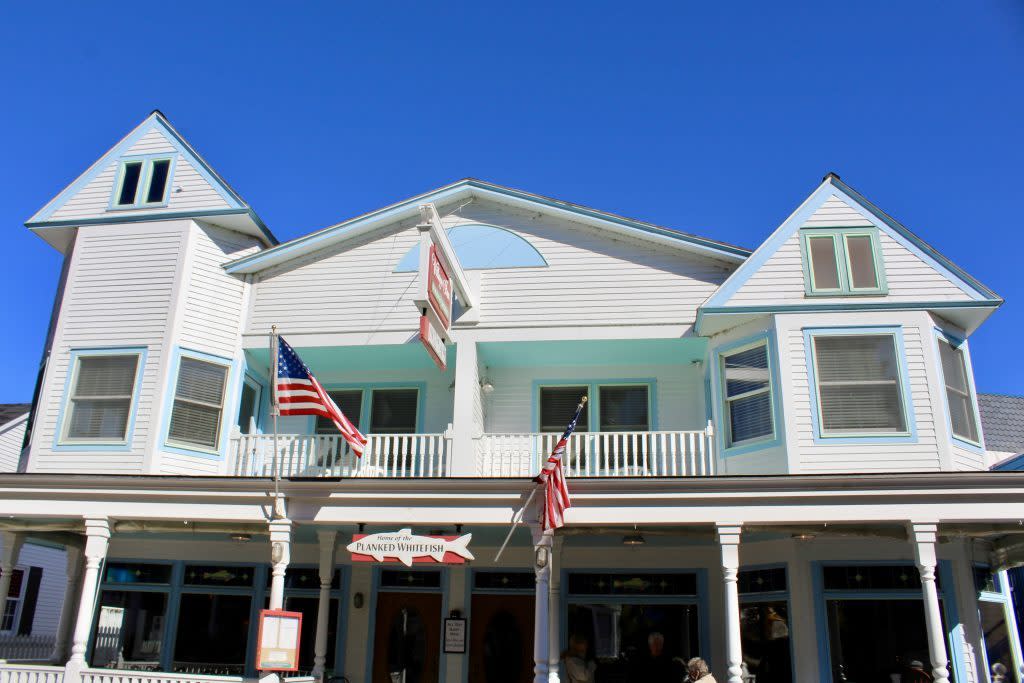 Flags fly outside Village Inn Suites in downtown Mackinac on a sunny day with clear blue skies