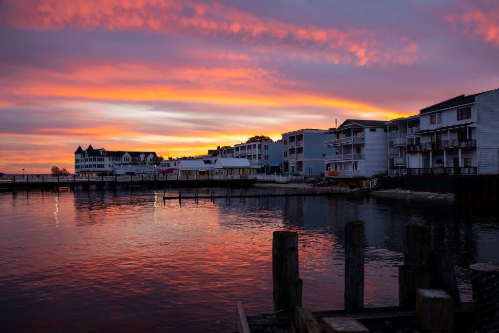 The sun sets behind the restaurants and places to stay on Mackinac Island’s Main Street on a gorgeous summer evening