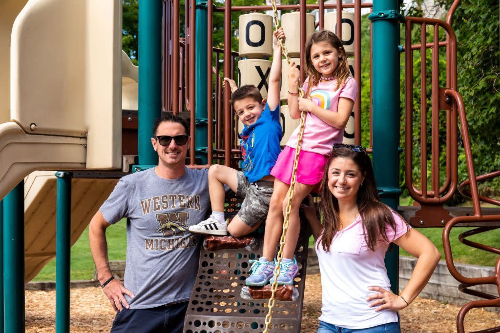 A family of four poses on the playground at Mackinac Island's Marquette Park