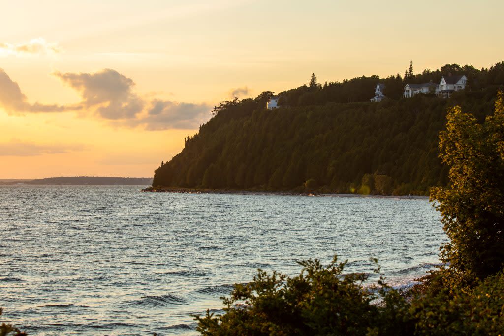 Cottages line the bluff high above the water around Mackinac Island on a beautiful summer evening