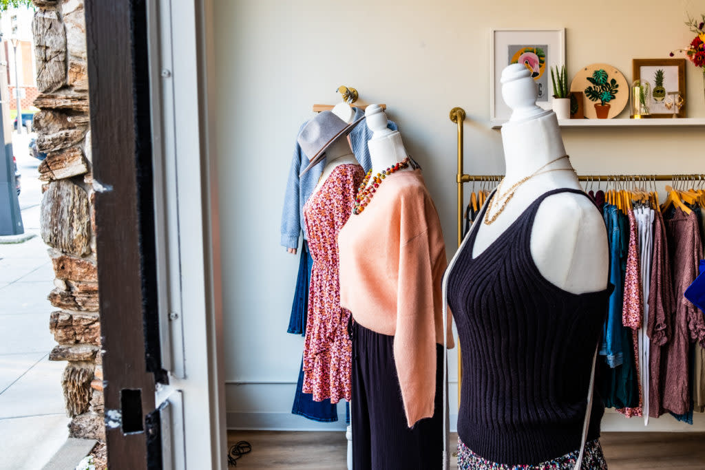 Outfits on display behind a window at Shop Privy in Wauwatosa