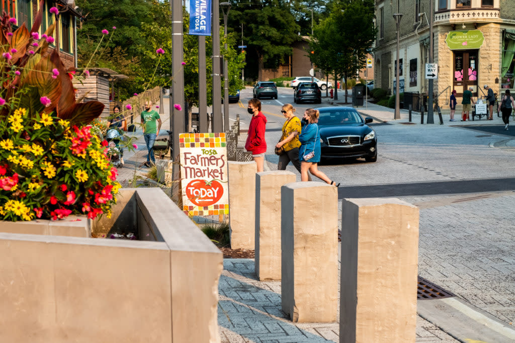 Tosa Village with Farmer's Market sign and people walking around