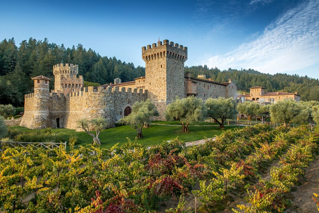 A stone castle-style winery with towers and surrounding vineyards in Napa Valley.