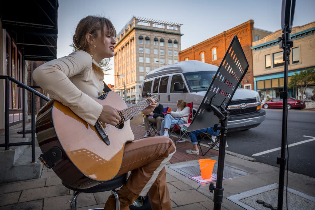 Girl playing guitar at Buskers' Bash