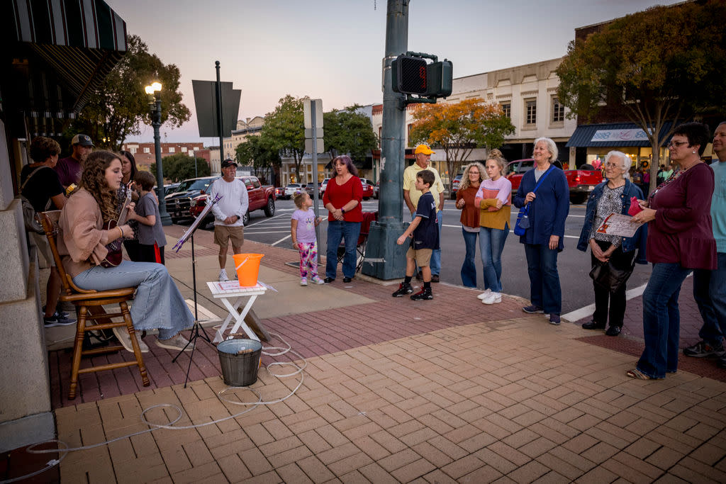People gathered in downtown listening to musician