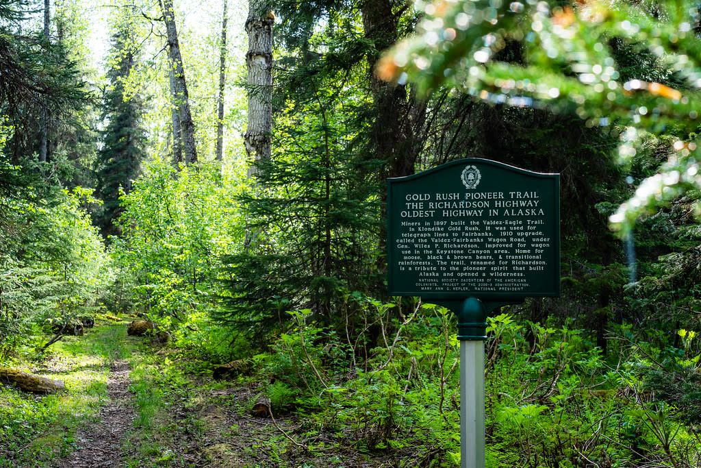 a historic marker sign along a forested hiking trail