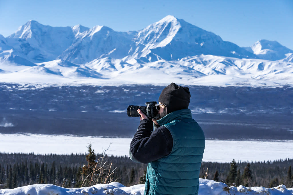 a photographer takes pictures of a mountain range