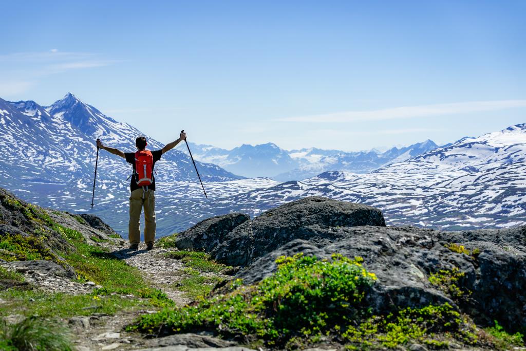 a person hiking in a mountain pass, holding trekking poles