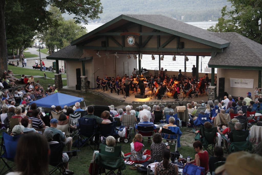 Outdoor band shell hosting a concert for a large audience
