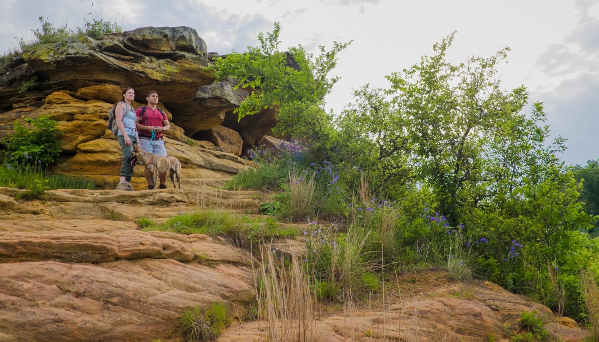 couple and dog hiking red sandstone rocks