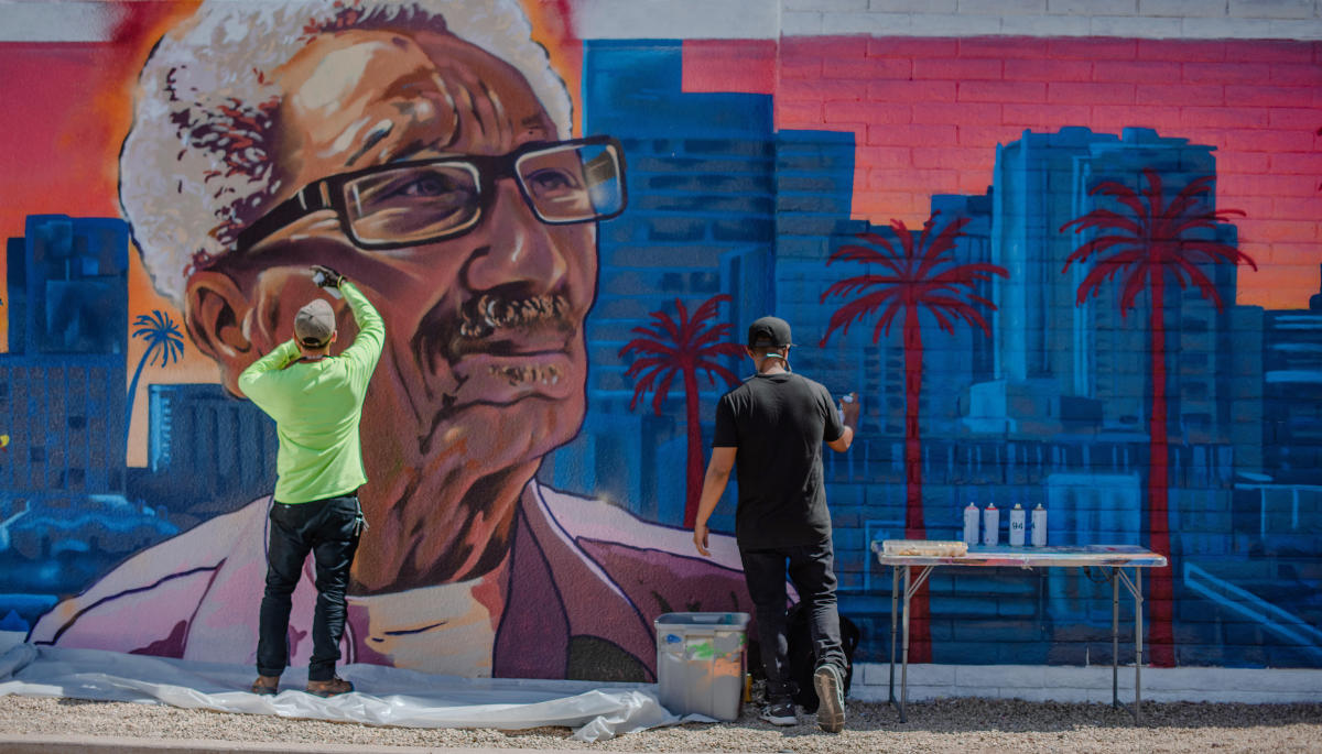 Two artists create a mural of Calvin C. Goode, Phoenix's second Black city councilperson at the time.