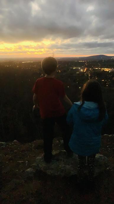 A child looks out over the city from Blevins Gap at sunset.