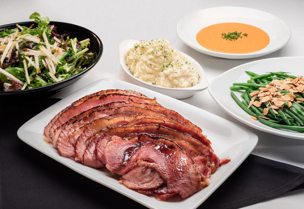 CARVE American Grille's Easter specials ham, green beans, soup and potatoes sitting on table.