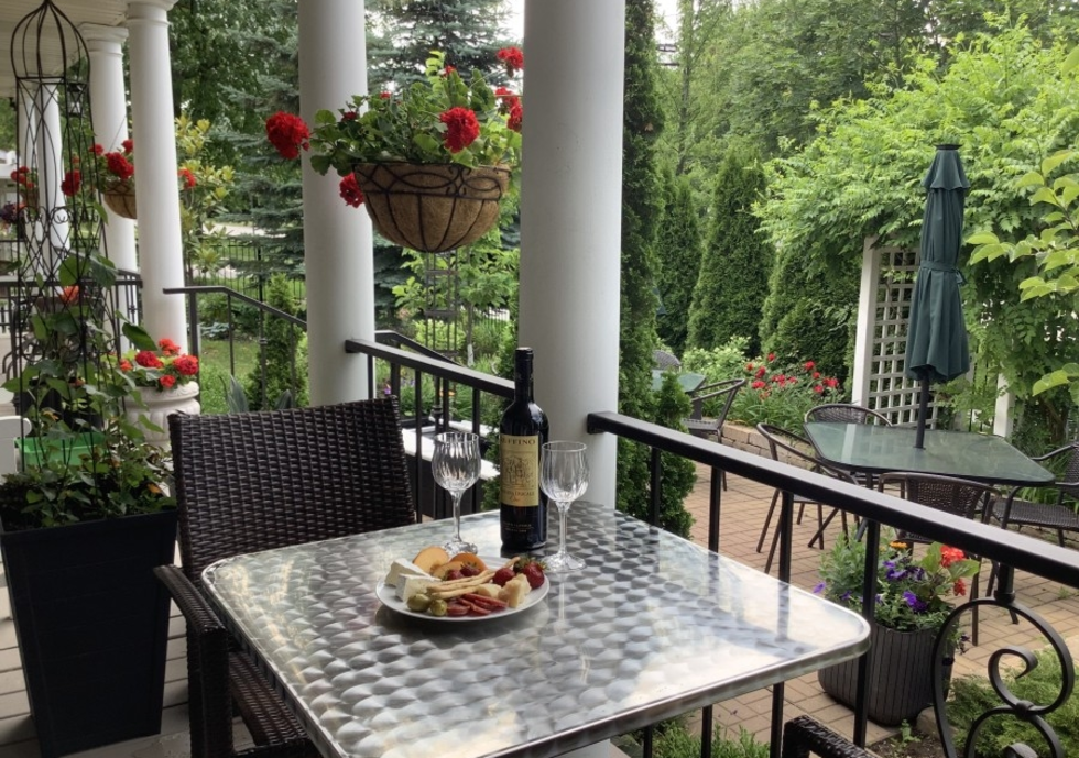 Breakfast dish on an outdoor balcony table, with flowers and extended patio in the background.
