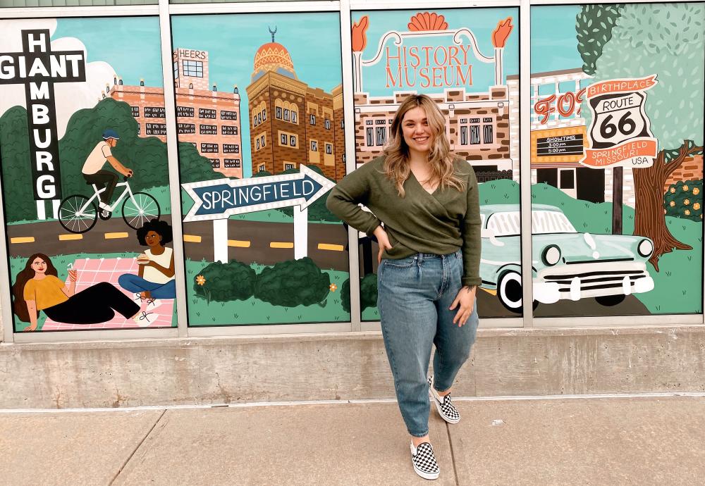 Artist standing in front of mural