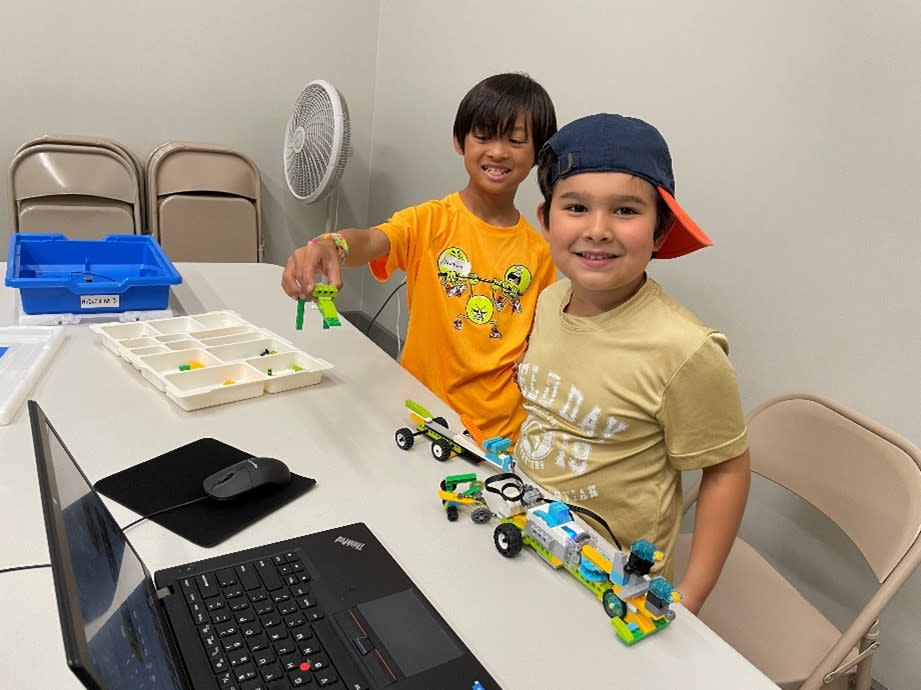 Two boys sit and build robots with legos at The Woodlands Children's Museum